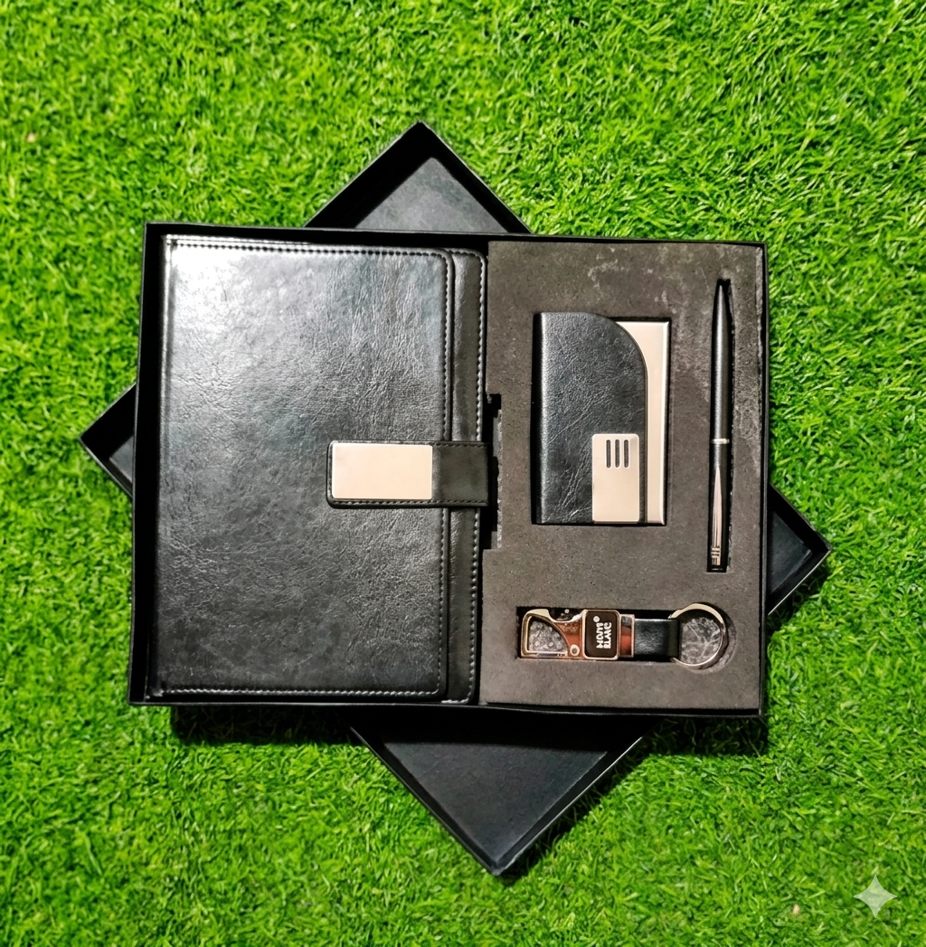 Black leather stationery set with notebook, pen, keychain, and card holder on a green grass background