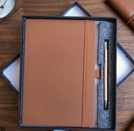 Brown leather notebook with a pen in a black box on a wooden surface
