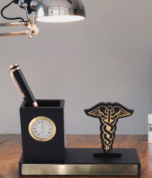 Black desk organizer with clock, pen holder, and caduceus symbol on a wooden surface.